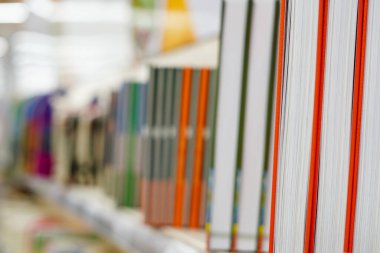 Modern şehir kitapçısının raflarında farklı renklerde kitaplar var.