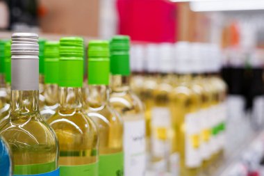 Markette çeşitli şarap şişeleri var.