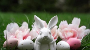 Tavşanlı Paskalya arkaplanı, yeşil arka planda yumurtalar ve çiçekler