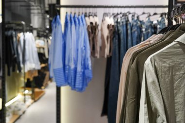Women's clothes on hangers in a retail shop. Fashion and shopping concept