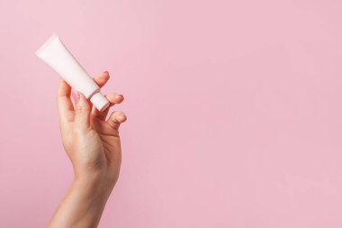 Vakfın ışık tüplü kadın eli ya da pembe arka planda kozmetik krem. Kozmetik güzellik ürünü markalaşma modeli. Boşluğu kopyala
