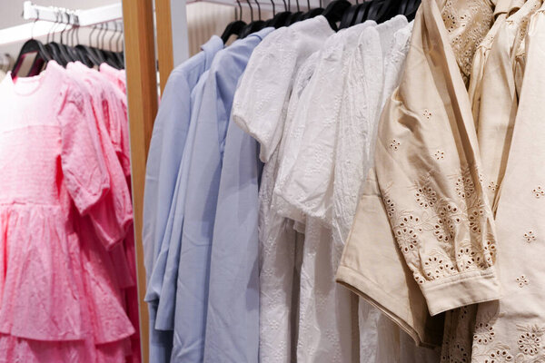 Детская одежда женские платья висят на вешалках в магазине