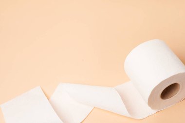 Metin için yeri olan bej arkaplan üzerine tuvalet kağıdı rulosu