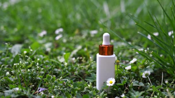 緑の自然の背景に白いガラス化粧品ボトル アロマセラピーオイル 天然化粧品のコンセプト — ストック動画