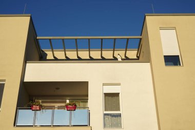 Apartman binaları. Güneşli yaz gününde modern konut mimarisi. Balkonda çiçekler