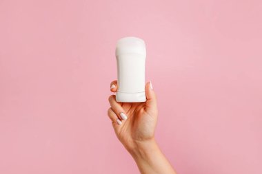 Pembe arka planda beyaz vücut deodorantı.