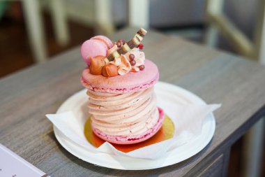 Pink macaroon dessert on the table in cafe , original and stylish dessert