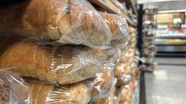 Bir markette rafa istiflenmiş paketlenmiş ekmek somunlarının yakın çekim görüntüsü