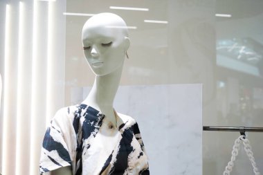 Modern soyut desenli bir elbise giyen, kapalı gözlü ve uzun kirpikli bir manken.