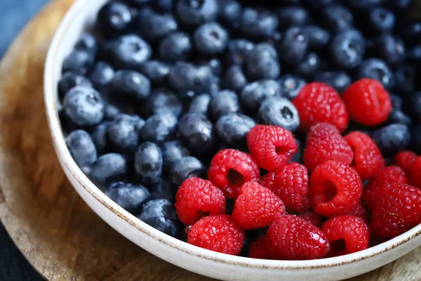 stock image Fresh selected raspberries and blueberries in a bowl. Healthy snack. Berries for dessert. Close-up.