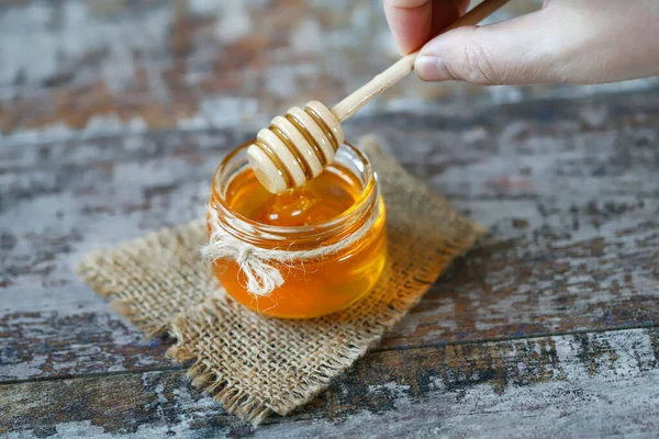 Fresh honey in a jar. Stick for honey. Harvest of honey. Flower honey.