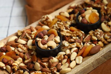 Tahta bir tahtada fındık ve kurutulmuş meyve karışımı ve bir kase. Sağlıklı tatlılar.