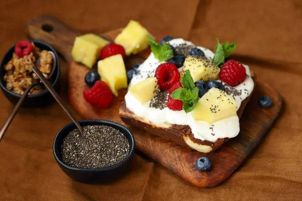 Healthy sweet toast with cream cheese, fruits, berries and chia seeds. Keto dessert.