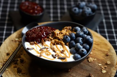 Çikolatalı granola, yoğurt, fıstık ezmesi ve ahududu reçeli.