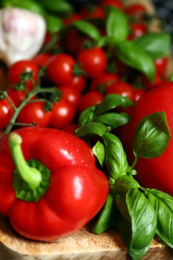 Taze sebze, kırmızı biber fesleğen, kiraz domatesleri ahşap tahtada.