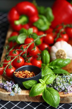 Taze sebze, kırmızı biber fesleğen, kiraz domatesleri ahşap tahtada.