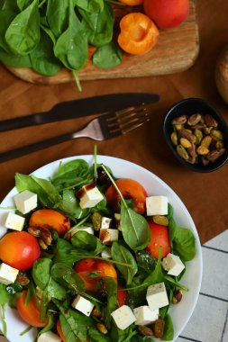 Beyaz tabakta roka ve kayısı ile salata.