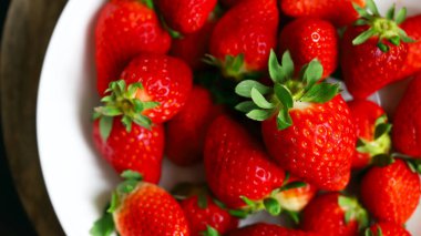 Taze olgun çilekler tabakta.