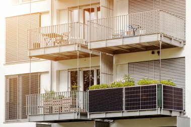 Apartman binasının balkonundaki güneş panelleri. Güneş Paneli Sistemi ve Yankı Binasının Kepenkleriyle Modern Balkon.
