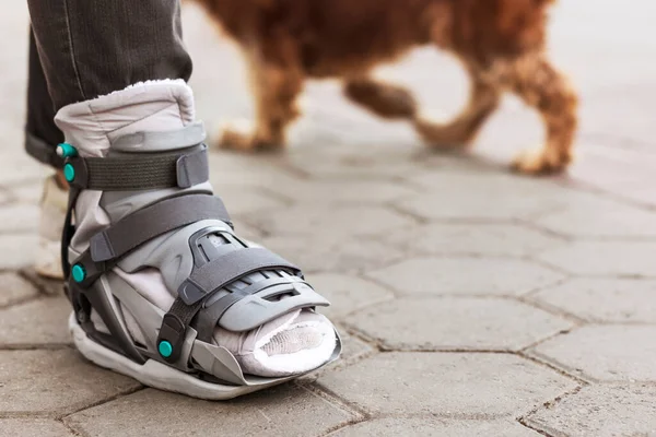 stock image Ankle Splint Boots or Leg Orthosis Bandage Shoes allows to walk the Dog Outdoor. 