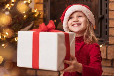 Noel Hediye Kutusu Evde Noel atmosferinde Çocuk Ellerinde. Mutlu Noeller Çocuk, Noel Hediyesi Aldı.