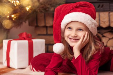 Noel Baba Şapkalı Noel Çocuğu Küçük Kız Noel ağacı ve şöminenin yanında rüya görüyor. Mutlu Noel Tatilleri