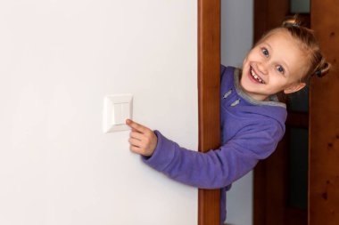 Switch off Light. Child Learns to  Turn off lights and Save Energy at home. Energy saving, Helping the Environment, eco-friendly lifestyle concept.
