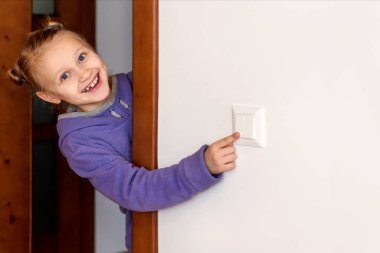 Turning off Light, Switch off Light, Save Energy, Energy Crisis concept. Child Girl Turns off the light. Copy space.