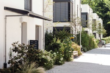 Binanın çevresindeki peyzaj işleri. Avrupa 'da Yeşillik veya Yeşillik Apartmanlı Modern Düşük Katlı Konut Binasının Dış Tasarımı