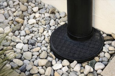 Downspout, Drainage stone Pebble around House, Outdoor close up. French Drain. Sewage pipe, Downpipe, Waterspout rainwater.