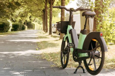 Bike or Electric Bicycle for Rental Service in Green City. Urban Electro bike charging battery in the Park. To rent