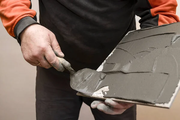 Tiler Hands Applaying Mortar on Tile. Laying Tiles, Renovation Floor concept