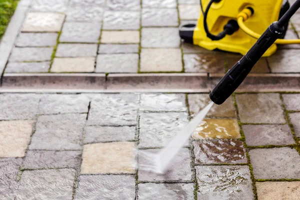 Cleaning Paving Stones in garden with Pressure Washer. Block Pavement Cleaning with high pressure washer. Copy space