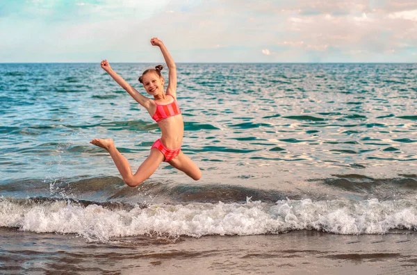 跳着的小女孩在海滩上玩得很开心 与子女共度快乐家庭暑假 — 图库照片