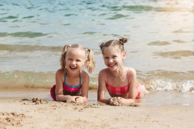 Deniz Sahilinde Yaz Eğlencesi. Mutlu Çocuklar yalan söylüyor. Deniz altyapısına gülüp eğleniyorlar..