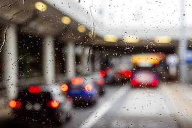 Pencereye Road Light Bokeh 'le Yağmur Damlaları, Araba Işıkları' yla Araba Camı 'nda Su Damlacıkları. Yağmurlu Hava 'da trafik sıkışıklığı.