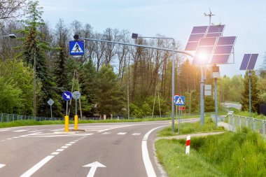 Trafik ışığı, yol işaretleri, yaya geçidi olan güneş paneli ve yel değirmeni enerjisi yolda. Eco Yolu 'nda yeşil enerji elementi.