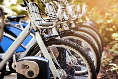 Bisiklet Paylaşım Sistemi. Halka açık otoparkta elektrikli bisikletler veya e-motorlar şarj ediliyor. Kiralık Sepetli Modern Mavi Bisikletler. Eko Taşımacılık kavramı