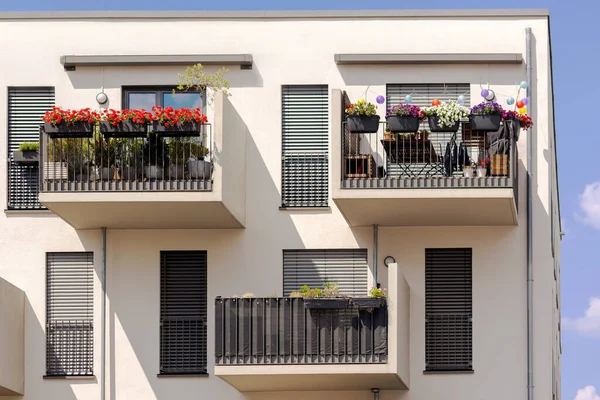 stock image Balcony of Modern Apartment Building. Modern Sunny Balconies with Flowers, Sun Protection Blinds Windows of Multistory Apartments. Exterior Design Facade High-rise Building.