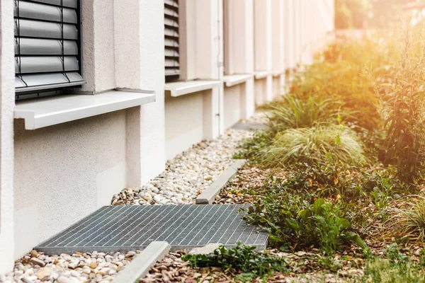 stock image French Drain System around Facade Building by House Wall  with Gravel and Grate. Modern Drainage System Outside House. Rain Water Protection