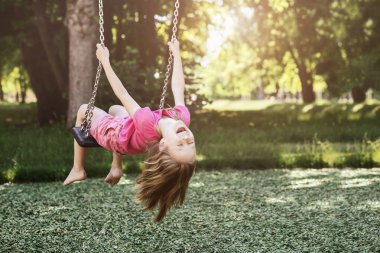 Çocuk Yeşil Doğa Arkaplanında Eğleniyor. Modern Swing in Park 'taki Duygusal Küçük Kız. Doğada Aktif Tatiller