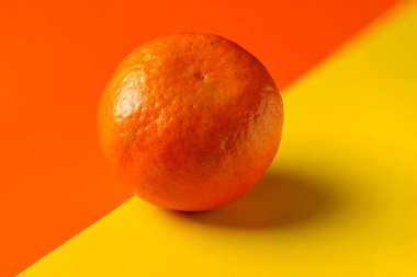 Mandarin close-up on yellow-orange background