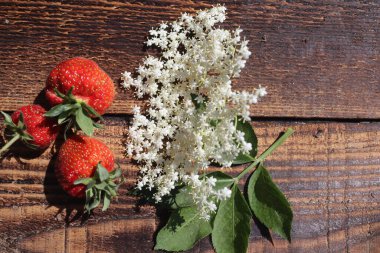Kırsal ahşap masada çilekler, üst manzara.