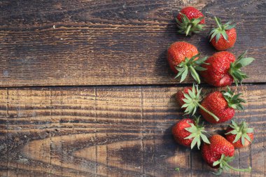 Kırsal ahşap masada çilekler, üst manzara.