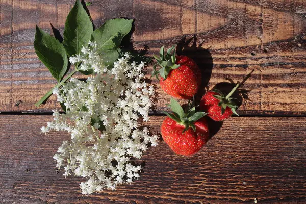 Kırsal ahşap masada çilekler, üst manzara.
