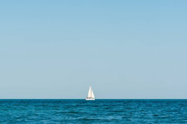 single white boat on the black sea
