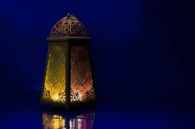 Lantern puts on table with dark blue background for the Muslim feast of the holy month of Ramadan Kareem.
