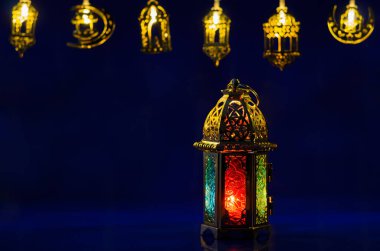 Golden lantern puts on dark blue background with decorated lights for the Muslim feast of the holy month of Ramadan Kareem.