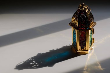 Golden lantern with shadow from dusk light for the Muslim feast of the holy month of Ramadan Kareem.