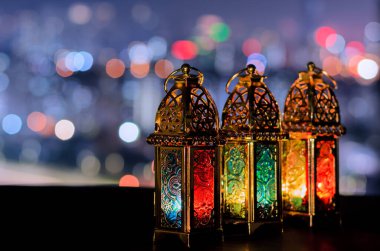 Kutsal Ramazan Kareem ayındaki Müslüman ziyafeti için gece gökyüzü ve şehir arkaplanı aydınlık fenerler..